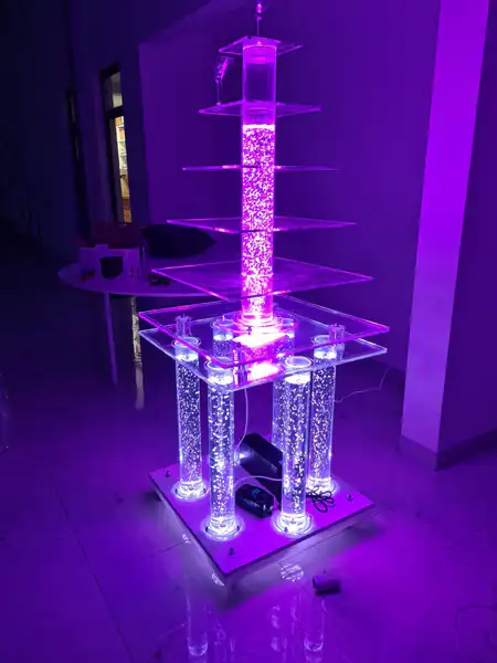 Četvrtasta šampanjac fontana u ljubičastom svetlu