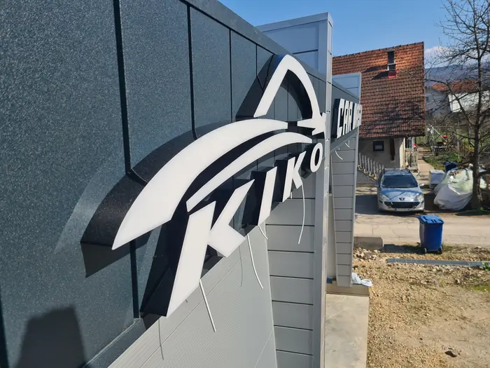 Logo Kiko Car Wash složene konture postavljen na sivu fasadu