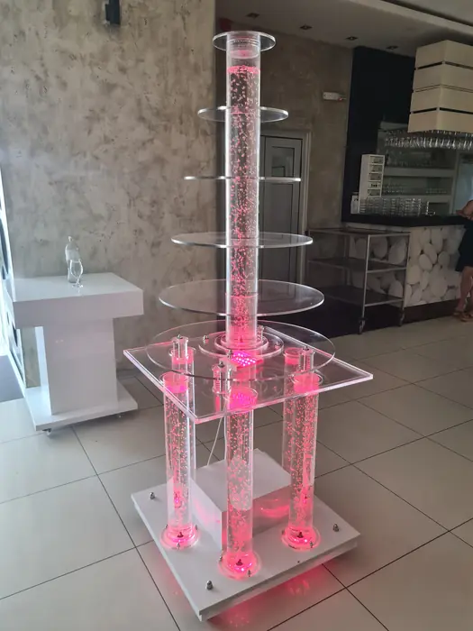 Okrugla šampanjac fontana u roze svetlu u svečanoj sali