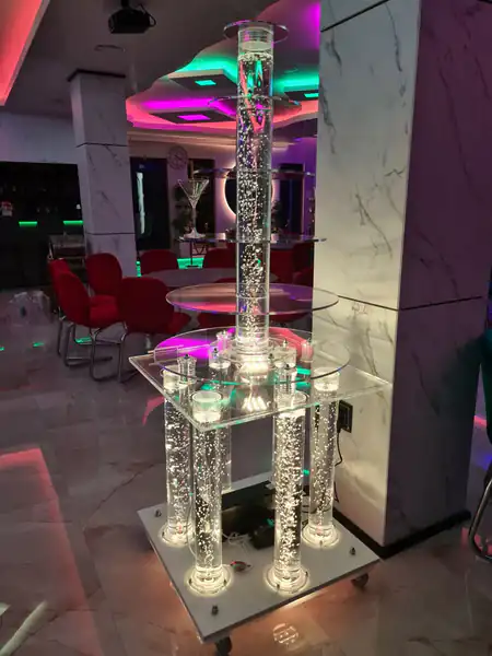 Okrugla šampanjac fontana u sali sa obojenim osvetljenjem