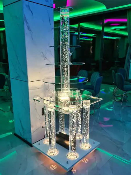 Okrugla šampanjac fontana postavljena na svetleća kolica