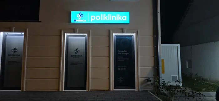 Svetleća tabla SI Medica poliklinika i osvetljeni paneli na fasadi noću