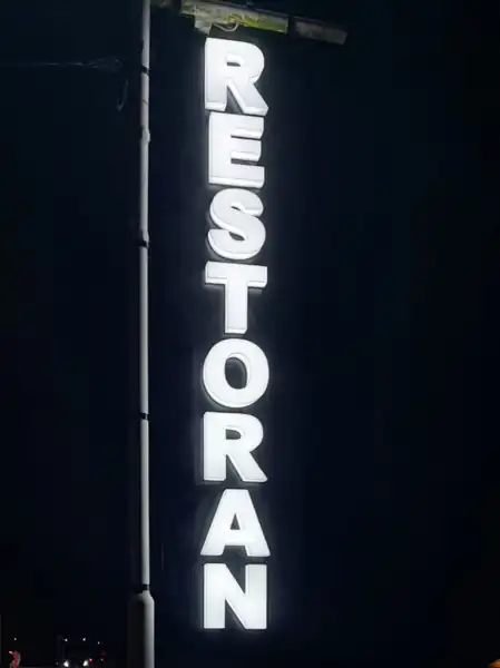 Ista reklama RESTORAN sa upaljenim svetlećim slovima noću