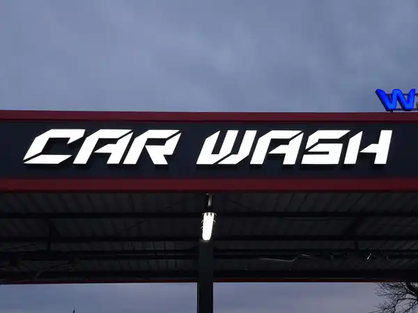 Svetleća slova CAR WASH na nadstrešnici perionice u sumrak